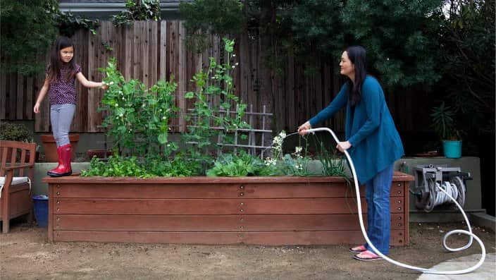 Mother and daughter gardening in backyard