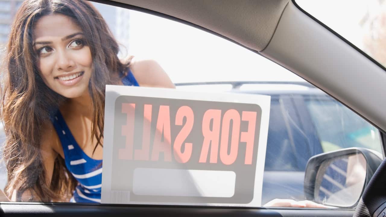 A woman looking at car for sale 