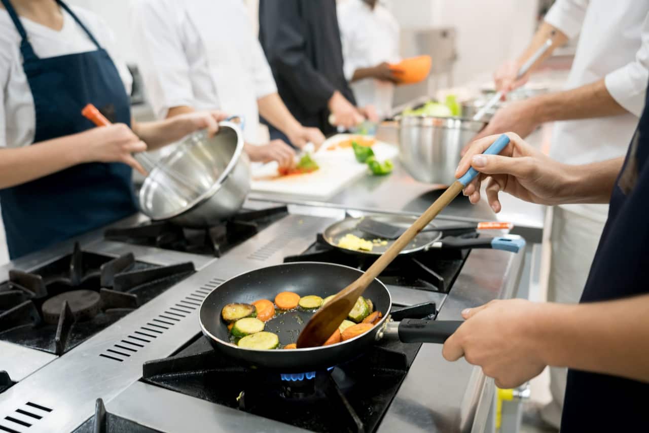 Unrecognizable people at a restaurant cooking meals