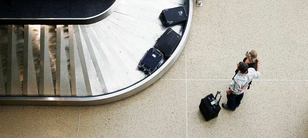 Couple waiting for luggage at baggage claim 