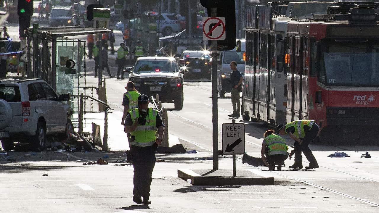 Police and emergency personnel work at the scene of where a car ran over pedestrians in Flinders Street in Melbourne