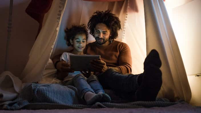 Father and daughter looking at digital tablet