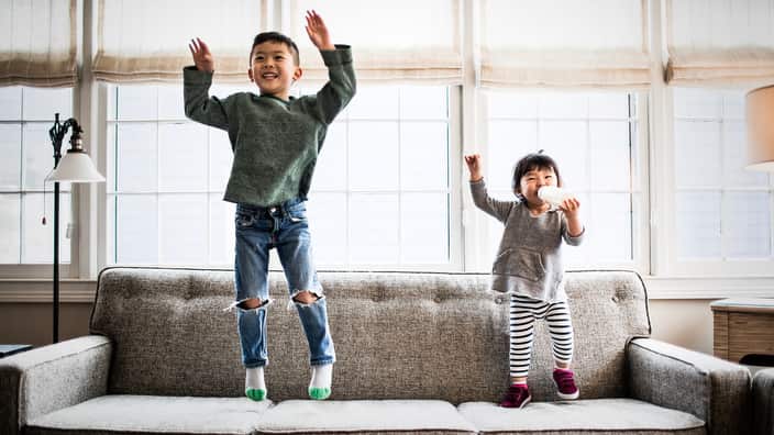 kids jumping on couch at home
