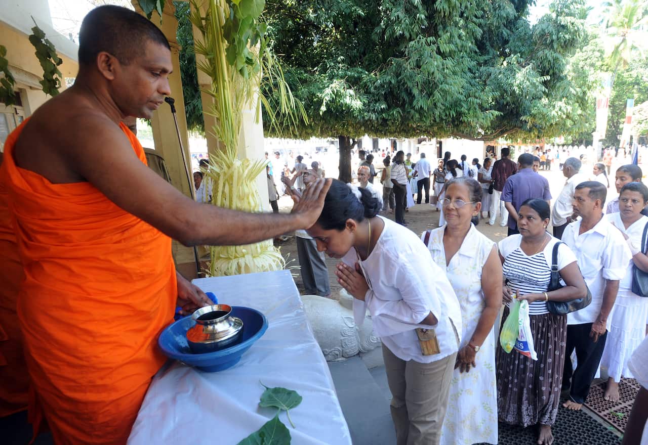 A Sri Lankan Buddhist monk annoints devo
