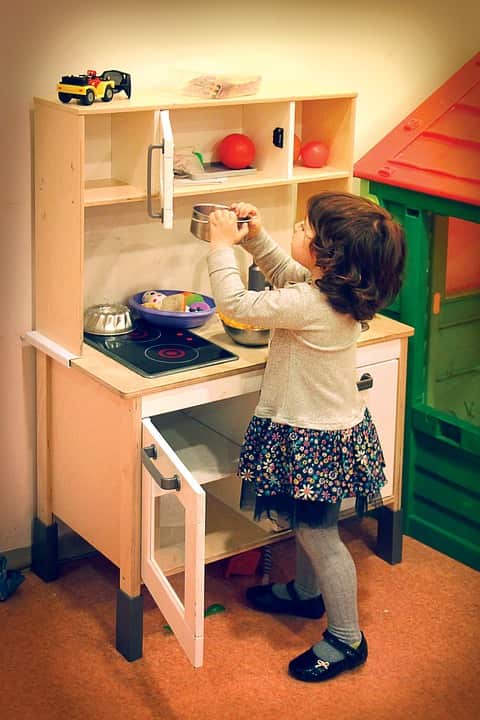 A girl playing with a toy kitchen