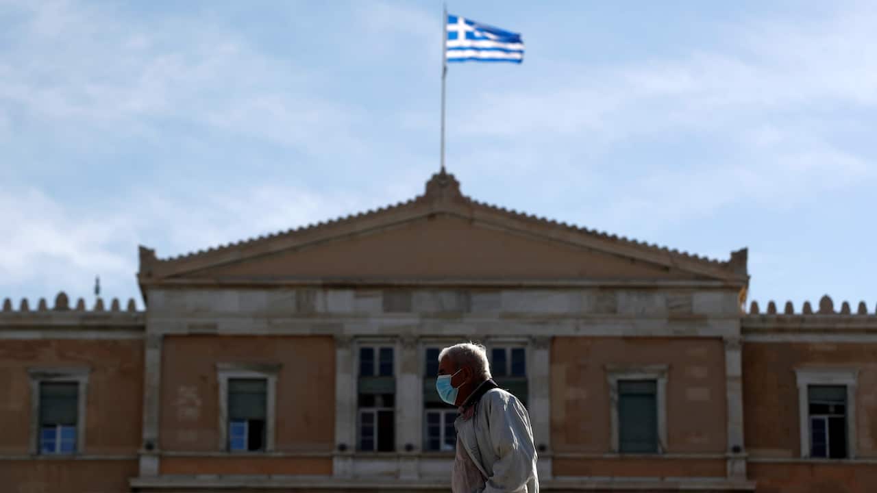 man wearing mask seen in front of Greek parliament.