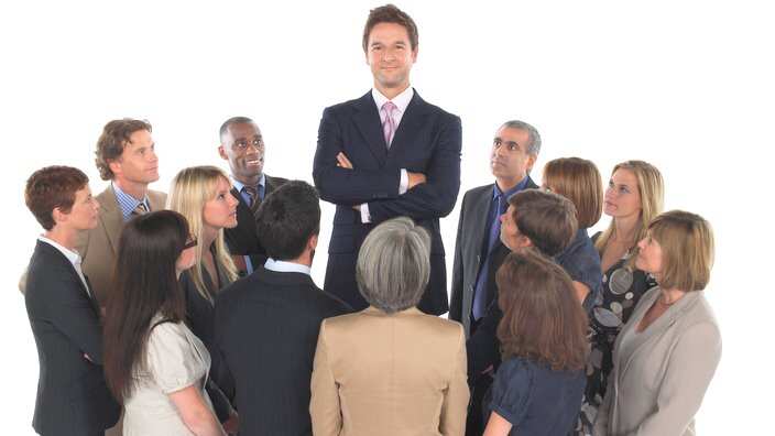 Group of Businesspeople Staring at Tall Man