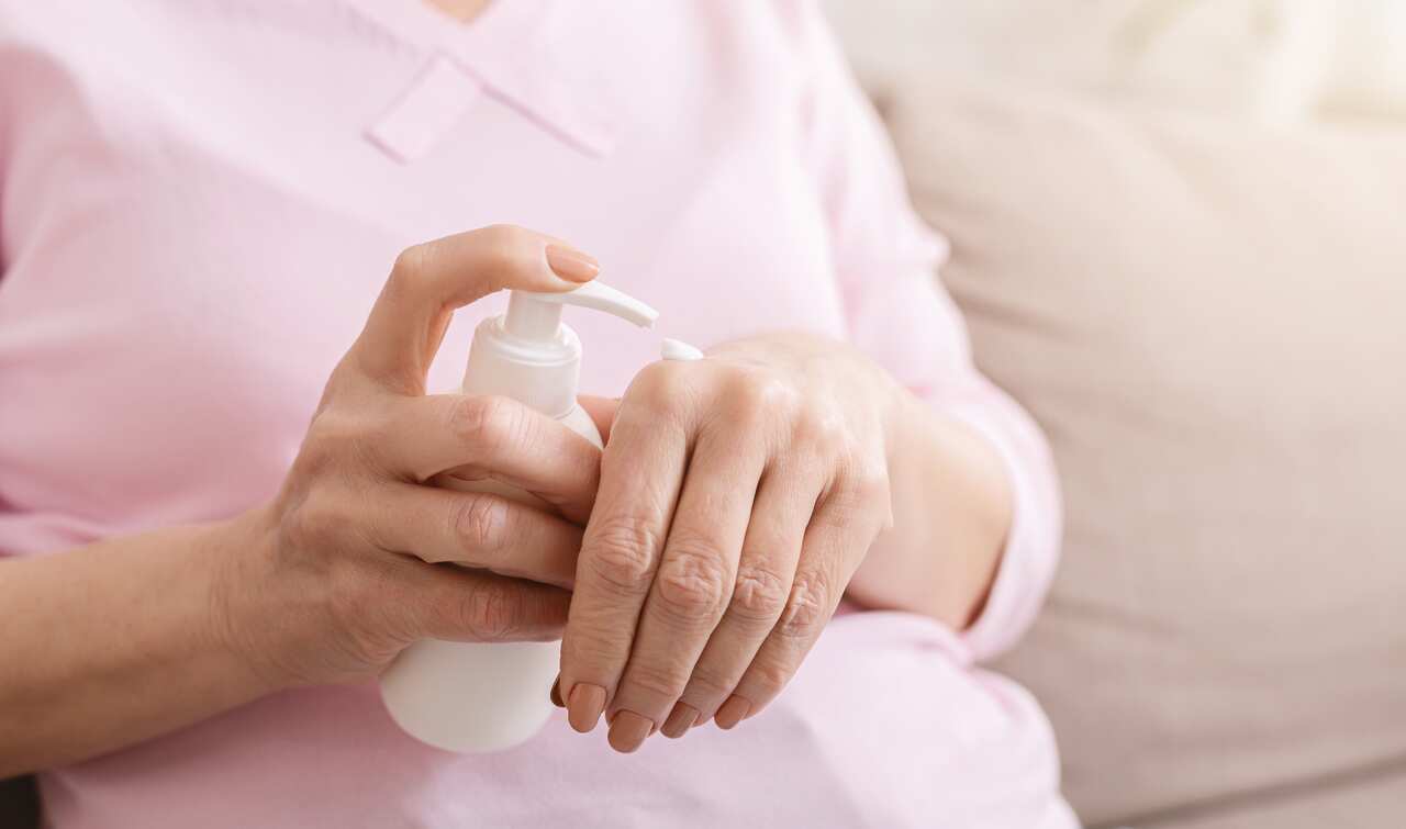 Hands senior woman with moisturizing cream closeup