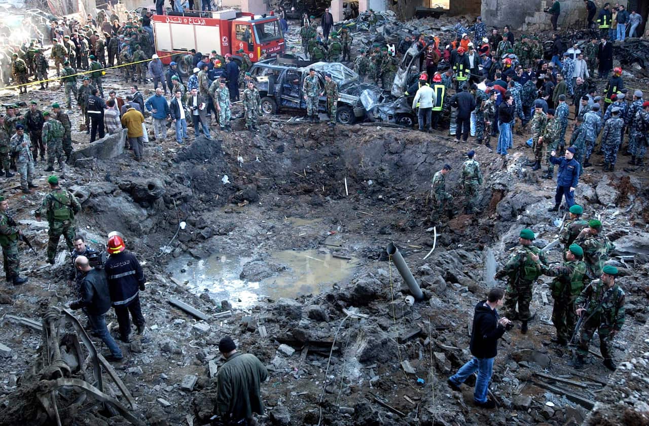 Feb 14 2005 rescue workers and soldiers stand around a massive crater after a bomb attack that tore through the motorcade of former Prime Minister Rafik Hariri 