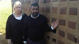Alice Guyett-Wood with Harmel Uppal pointing to the niche in the cemetery wall, where Pooran's ashes had been stored for decades