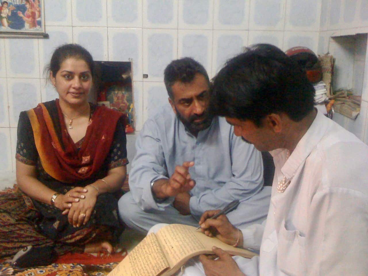 Harmel talking to the priest at Haridwar as Manpreet looks on