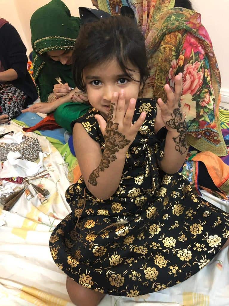 A girl gets her hands painted with henna to mark the festival of Eid