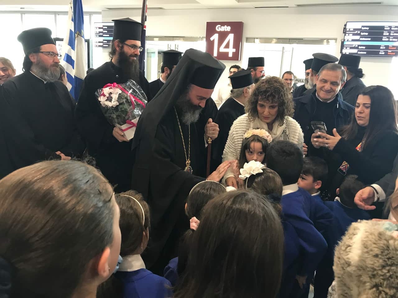 Archbishops Makarios "high fives" with children of the Orthodox faith