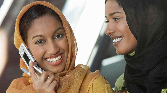 Two muslim woman one talking on mobile