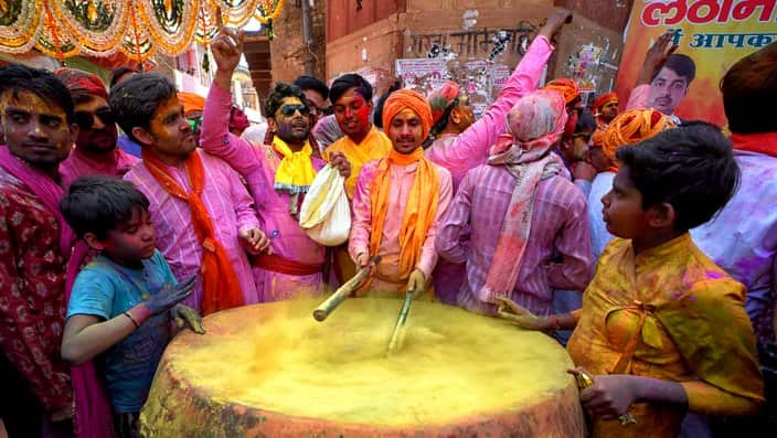 People seen playing the drum before starting the  Holi Festival in India