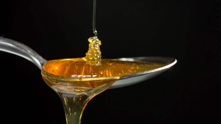 honey dripping on a spoon