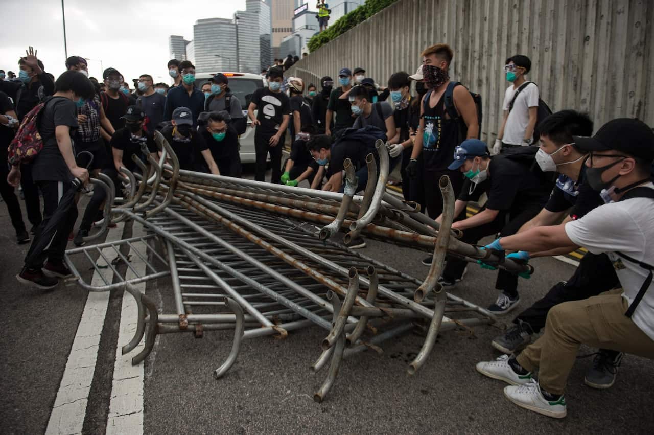 Protesters use barriers to build barricades during a rally against an extradition bill outside the Legislative Council in Hong Kong, China, 12 June 2019