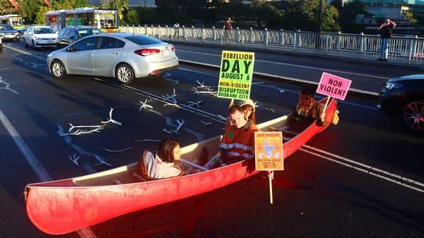 Two men and two women from the “Extinction Rebellion SEQ” group this morning placed the canoe on the Victoria Bridge in the city’s CBD about 7.30am and sat in it while waving protest placards. (Facebook)