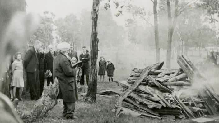 An image from 1939 of the cremation of an Indian settler Rule Singh. Many people from the town were present, including children, while a fellow countryman is performing the last rites.