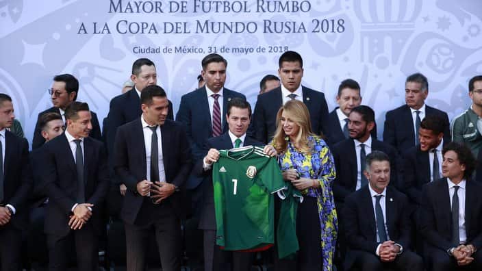 Mexican President Enrique Pena Nieto (C-L) and his wife Angelica Rivera (C-R) receive a T-shirt of the Mexican national soccer team.