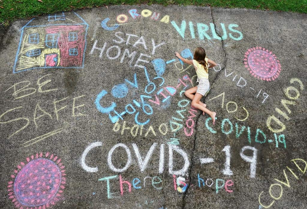 A girl drawing and writing letters with chalk at a house in the Gold Coast