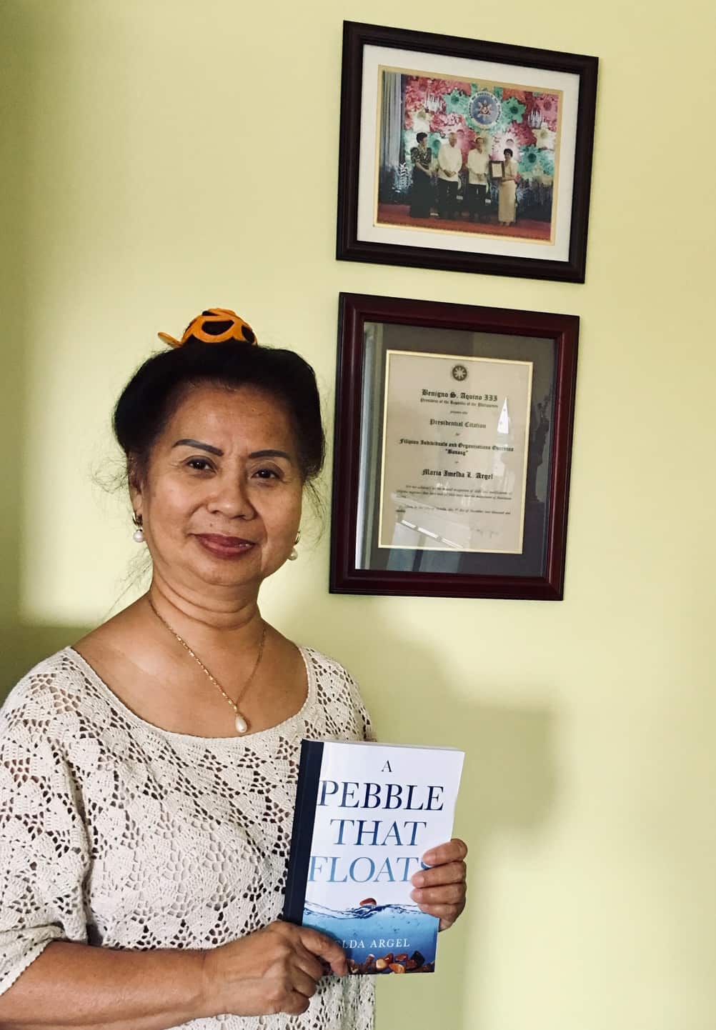 Imelda with her memoir and her award from the Philippine government on the background 
