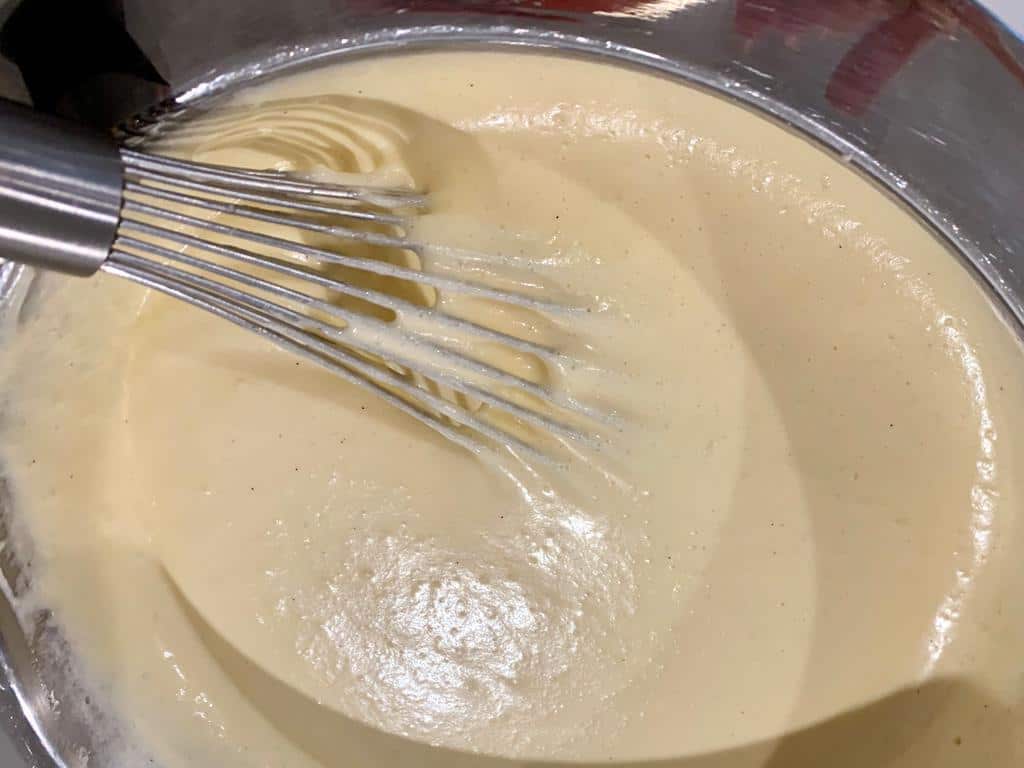 Using an egg beater to blend the cake mix with the hard peaks.