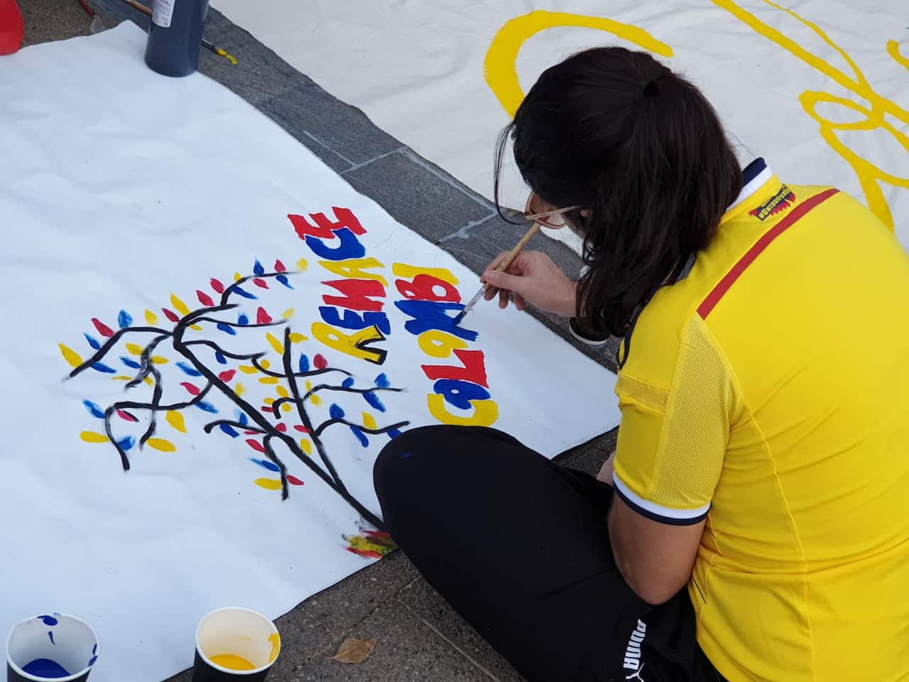 A Colombian woman in Sydney paint a banner in the Addison Road Community Centre, in Sydney.