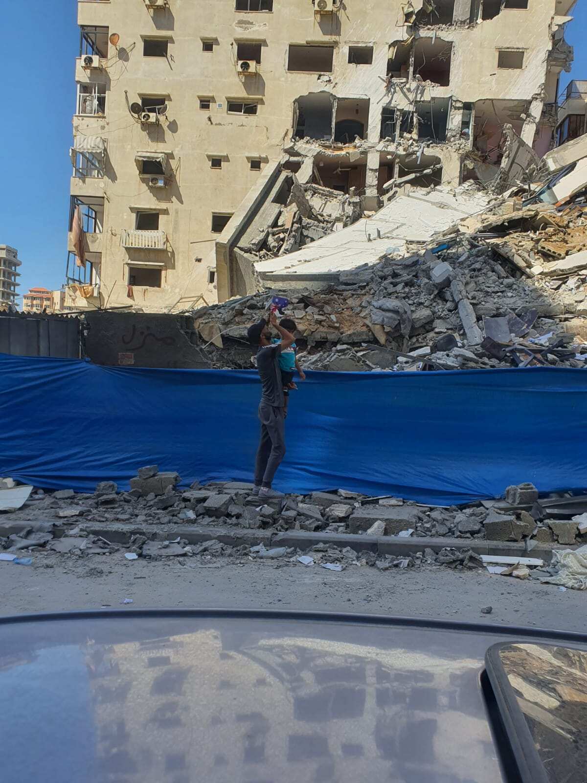 Fadi Hammad and his son at the site where their building once stood in Gaza.