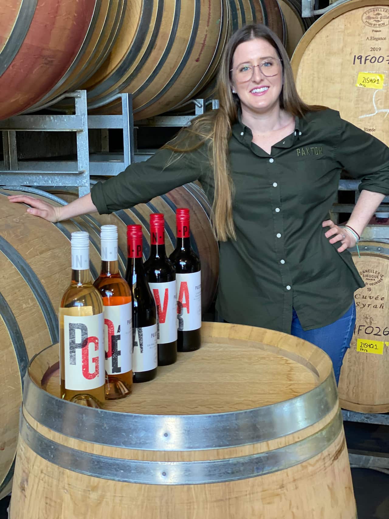 Ashleigh in her cellar with some wine bottles