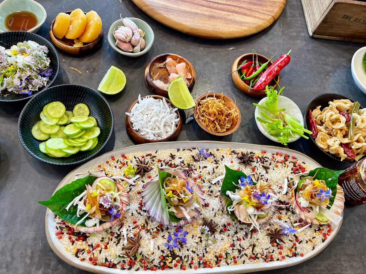 หอยเชลล์ย่างพร้อมมะม่วง ส้มโอ และน้ำยำรสจัดจ้านเป็นอาหารไทยประยุกต์ที่คุณรุ่งสาธิตให้เอสบีเอส ไทย ชมและชิม