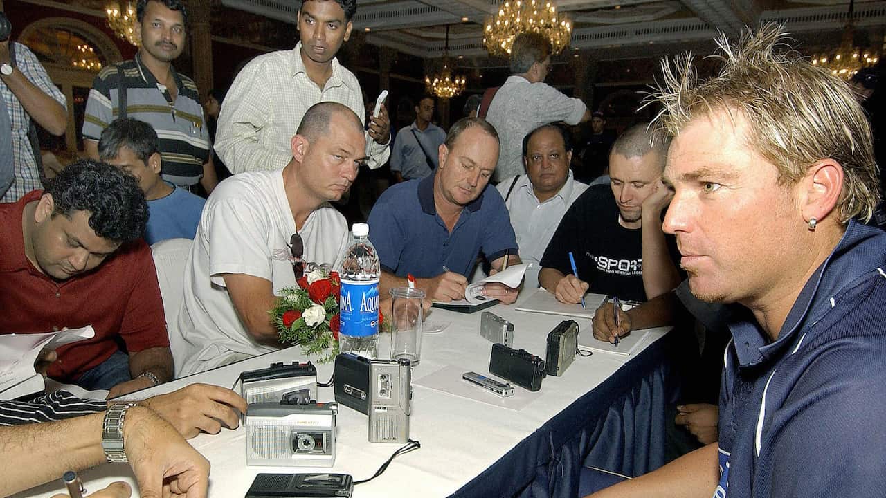Shane Warne (R) talks to the media during a meet the press session, after the Australian team's arrival in Bombay, 26 September 2004.