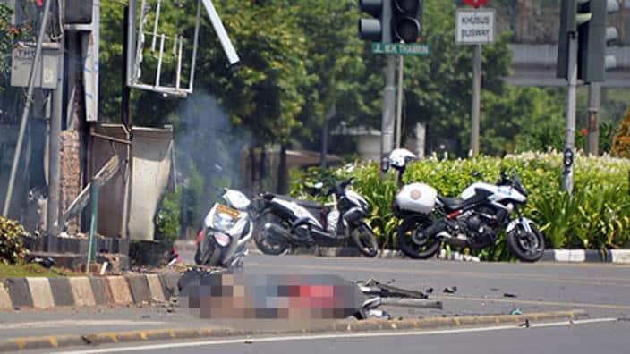 Three bodies lie on the street next to a damaged police post after a series of blasts hit the Indonesia capital Jakarta. (Getty)