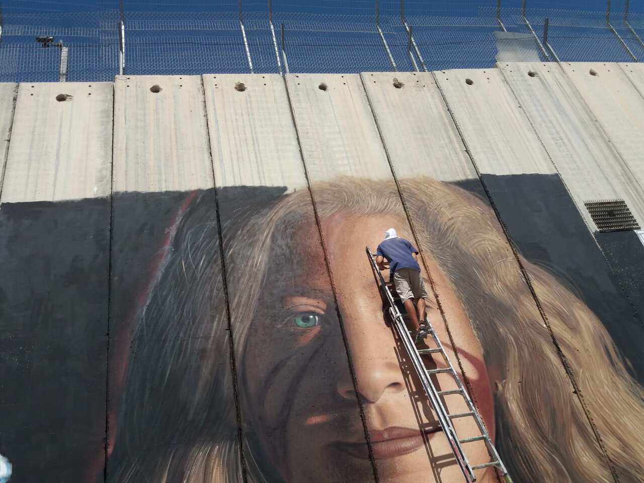 Italian Artist Jorit painting a portrait of Ahed  Tamimi