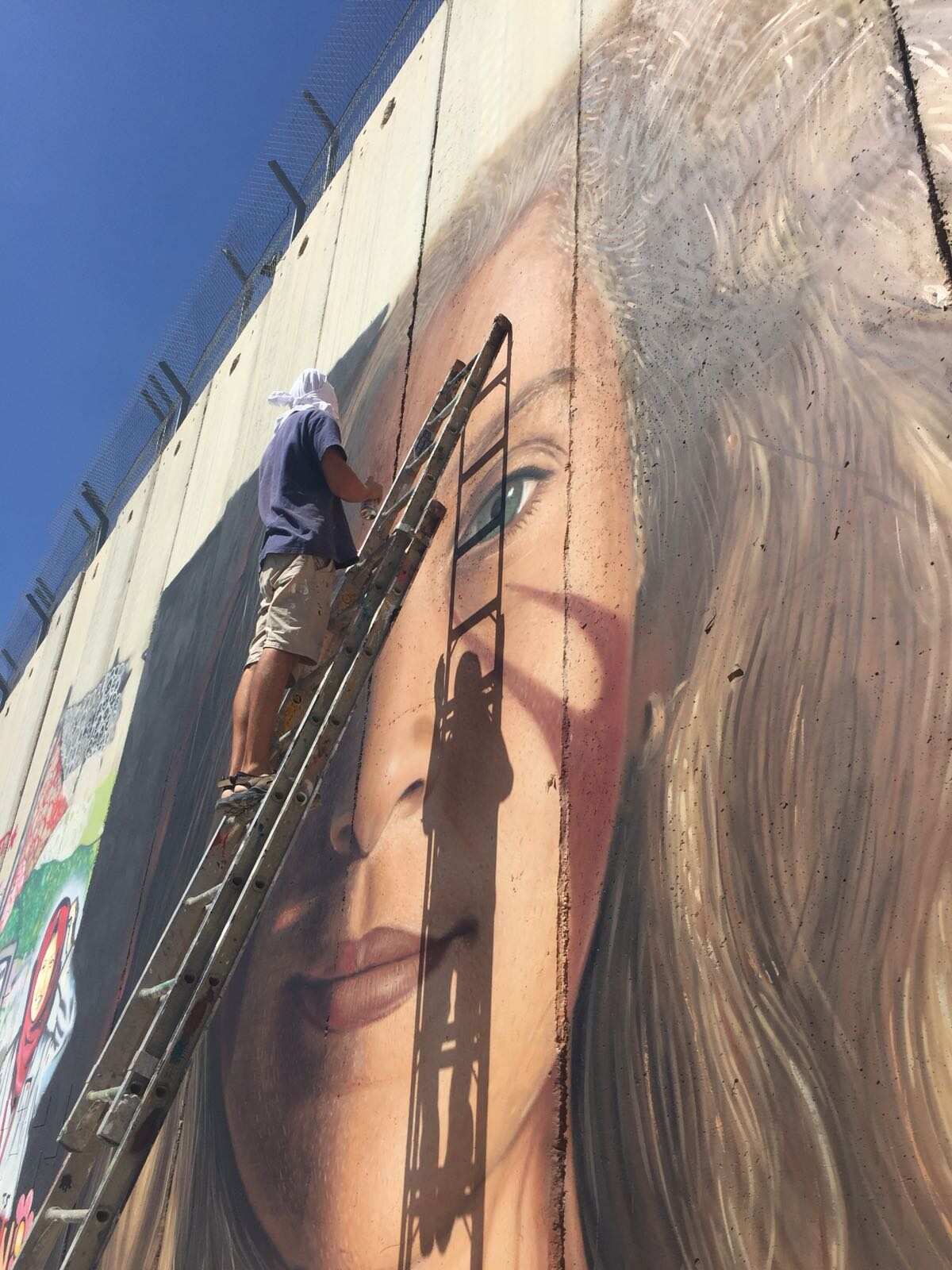 L'artista campano Jorit durante la realizzazione del ritratto di Ahed  Tamimi.