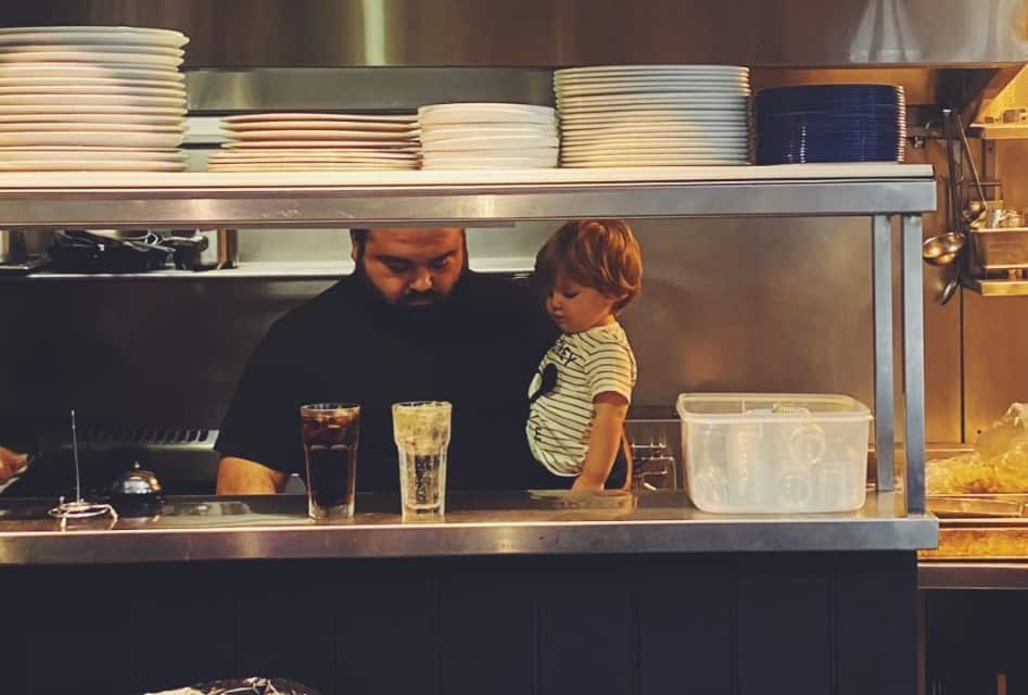 Jovan in the Pub Life kitchen with his kids, during pre-pandemic times. 