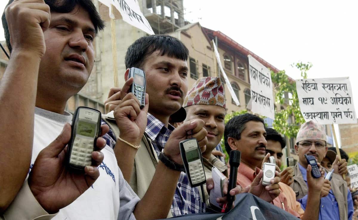 A group of journalists hold dead mobile phones, whose service has not been restored, in a protest rally against the government plan to muzzle the press.