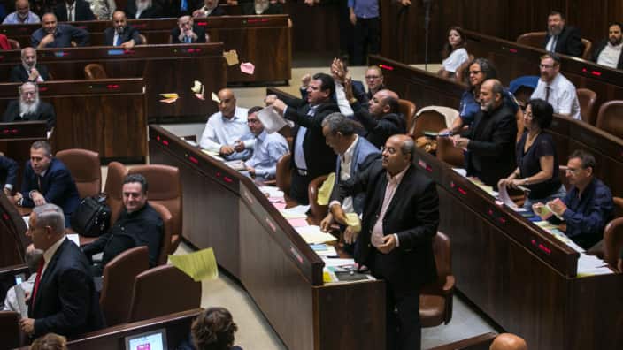 Arab lawmakers stand up in protest during a Knesset session in Jerusalem