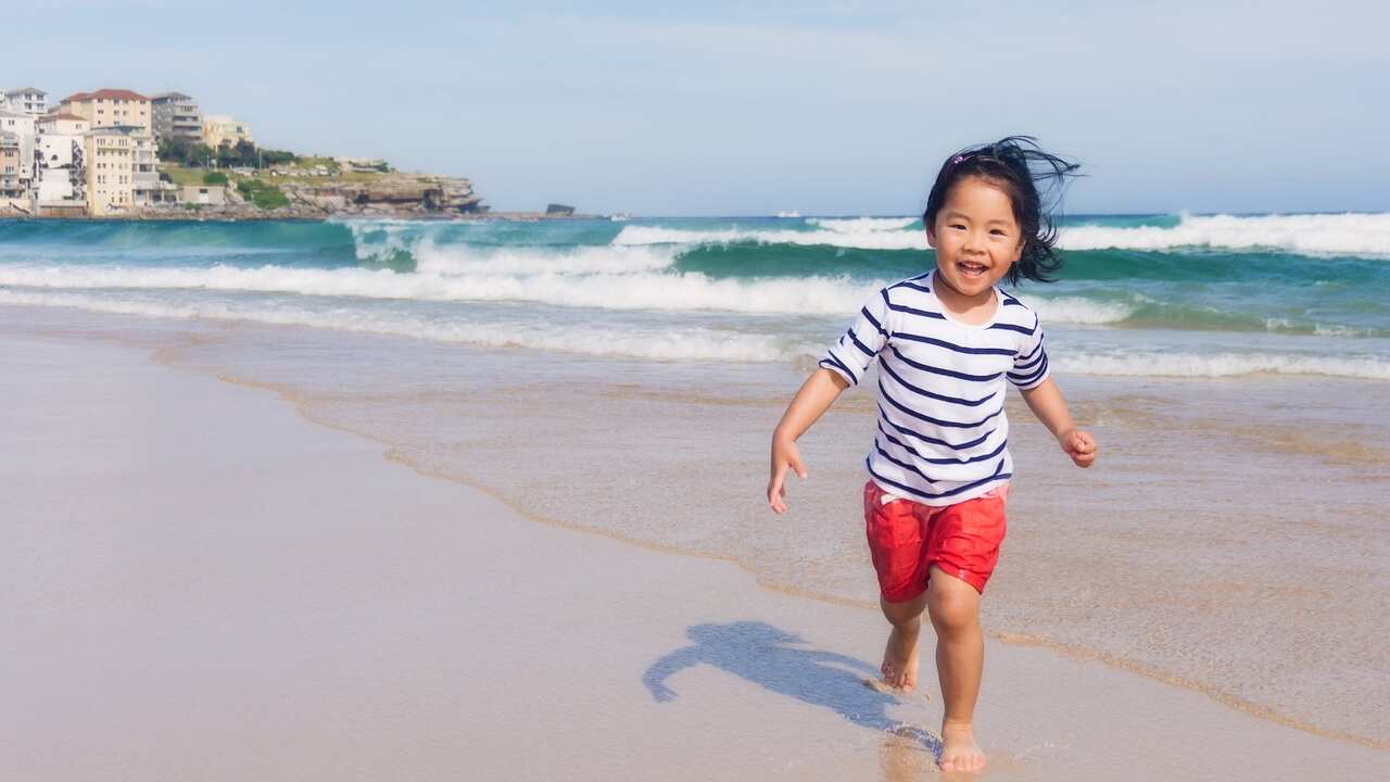Young Girl Running and Smiling Happily At Beach