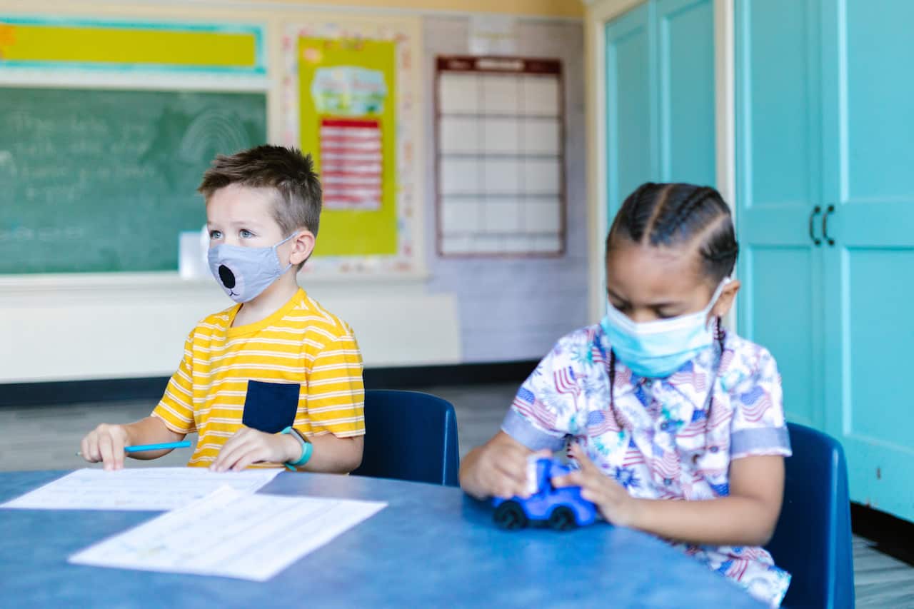 Children wear mask while studying in a classroom