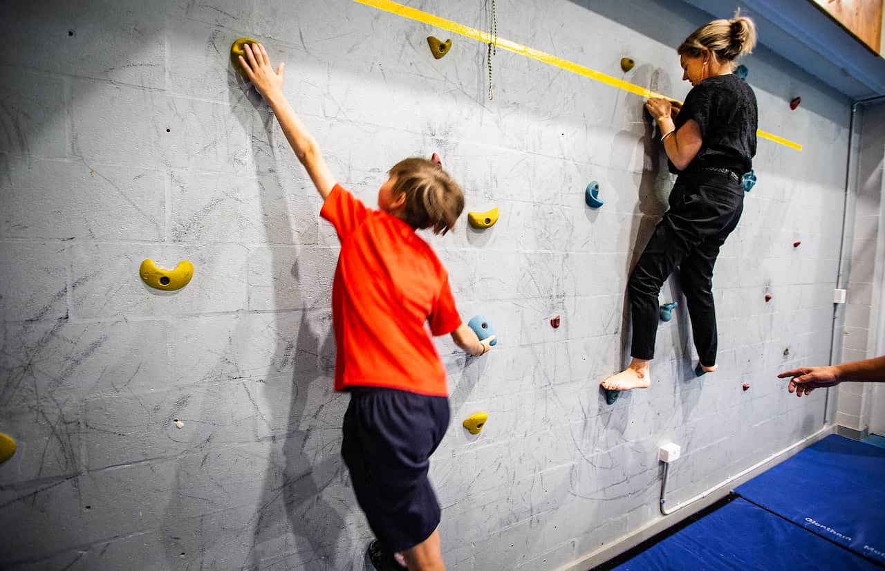 kids trying to climb a wall