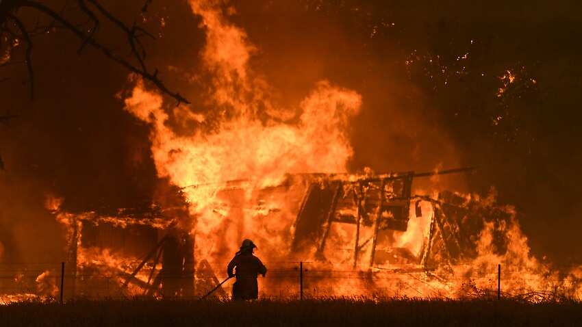 NSW Rural Fire Service crews fight the Gospers Mountain Fire as it engulfs a structure at Bilpin. 