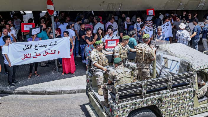Lebanese army soldiers on military vehicles patrol the road as Lebanese, Palestinian and Syrian activists during a protest in front the Labor Ministry in Beirut
