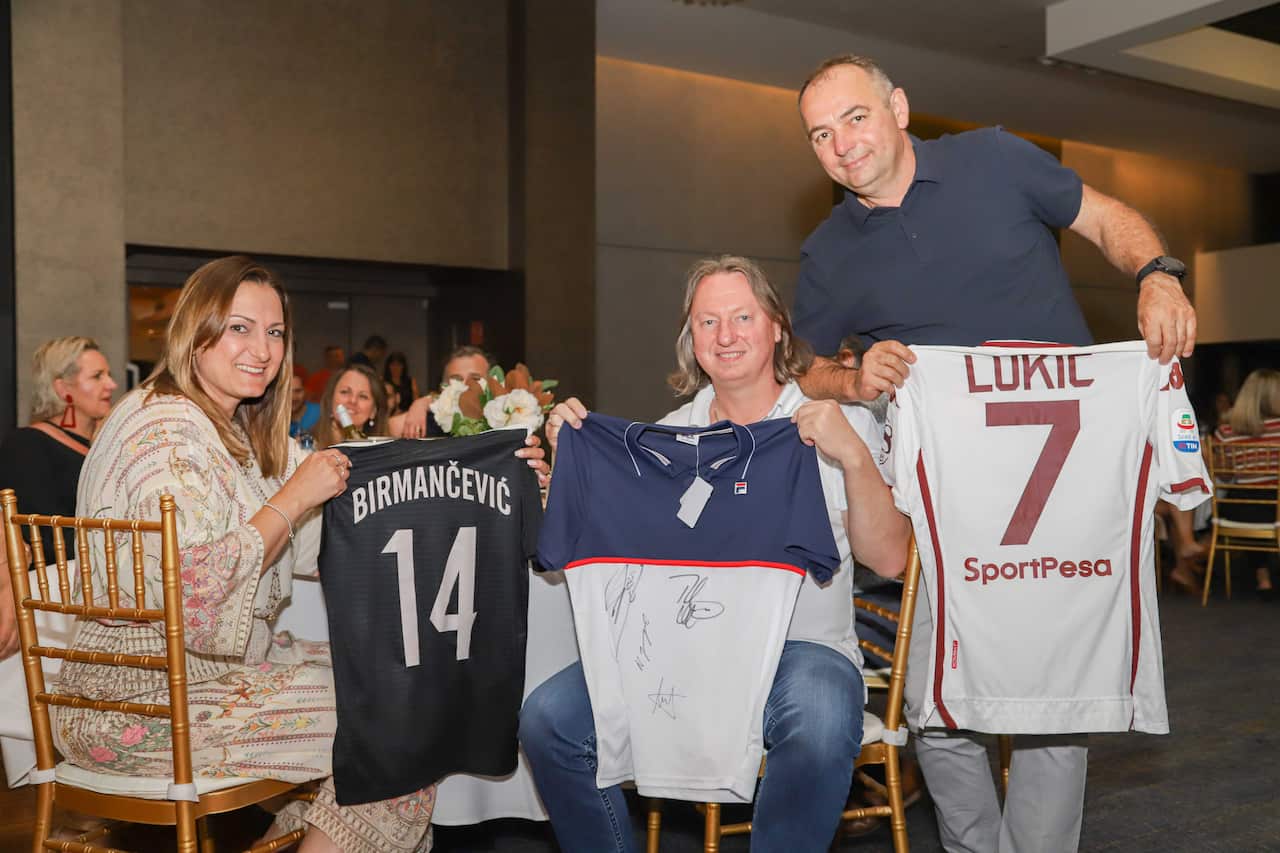 Nebojsa Stevanovic (right), Zoran and Lidija Ilic with football jerseys purchased during a charity event in the Serbian Centre in Bonnyrigg  