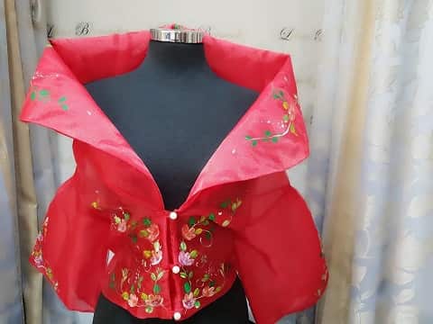 A red Baro't Saya top with floral embroidery created by Lilian Bermudez