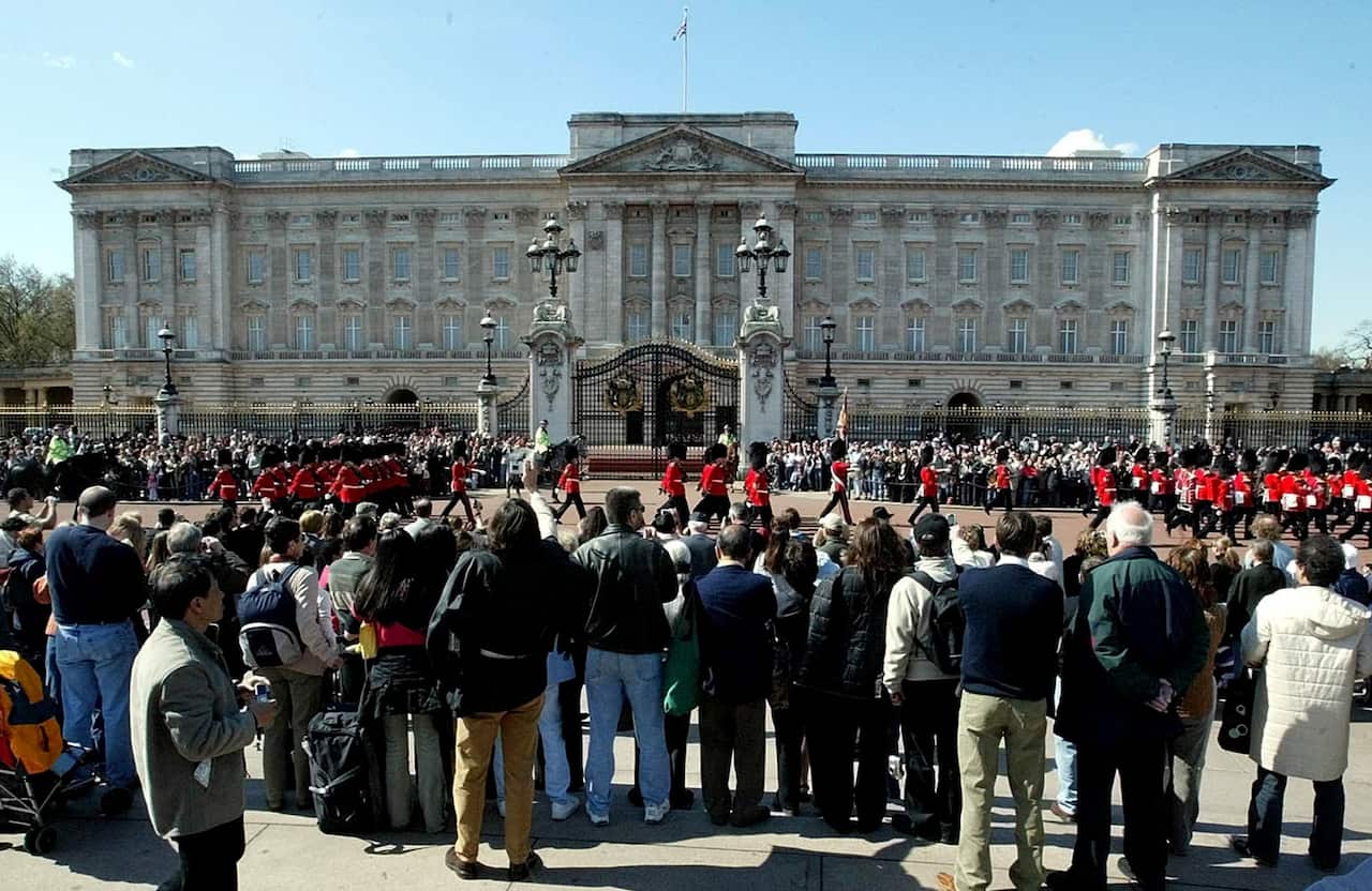 Tourists gather at Buckingham Palace, England, April 11, 2005 to watch the daily spectacle of the Changing of the Guards. (AP Photo/Dave Caulkin)