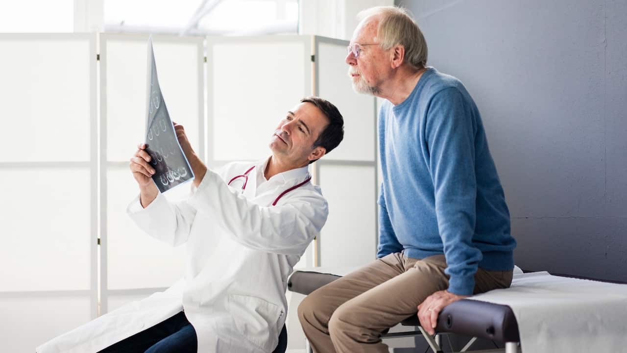 Male doctor showing man x-ray