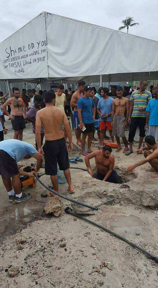 Holes being dug in the earth, so that the detainees can drink water after the supplies have been cut