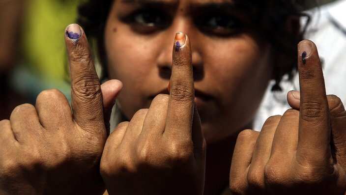 Indian voters show their ink marked finger after casting their votes