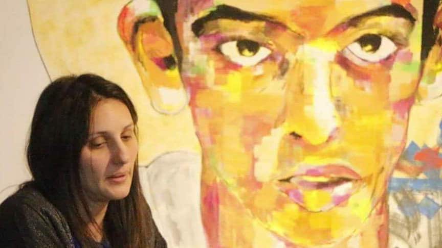 Marwa Kenawy in front of a large portrait of her son Youssef Alaraby 